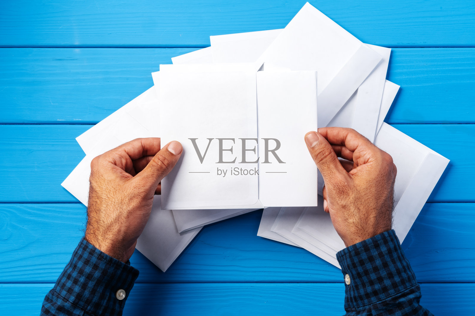 商业信函。俯视图的男子手握模型信封和信件。副本的空间。照片摄影图片