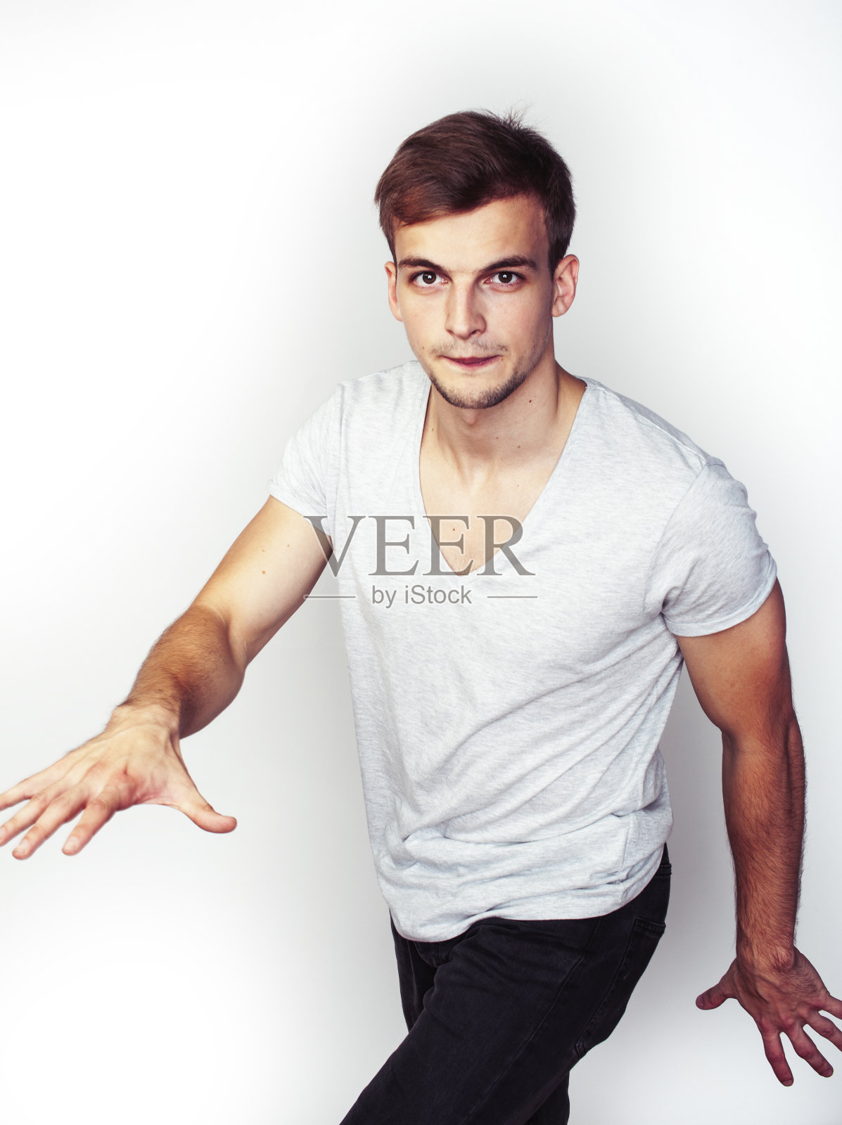 年轻帅气的十几岁潮男摆着情感的姿势,开心的微笑着在白色的背景下孤立,生活方式的人的概念照片摄影图片