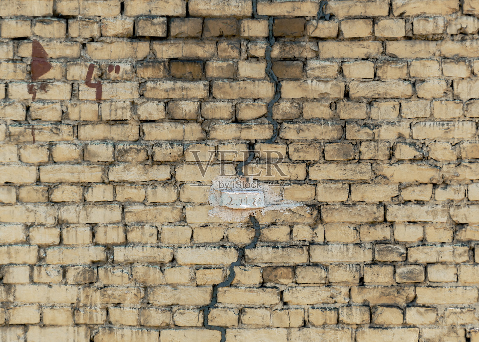 砖墙上的标志,用于监测建筑物裂缝的扩展。照片摄影图片