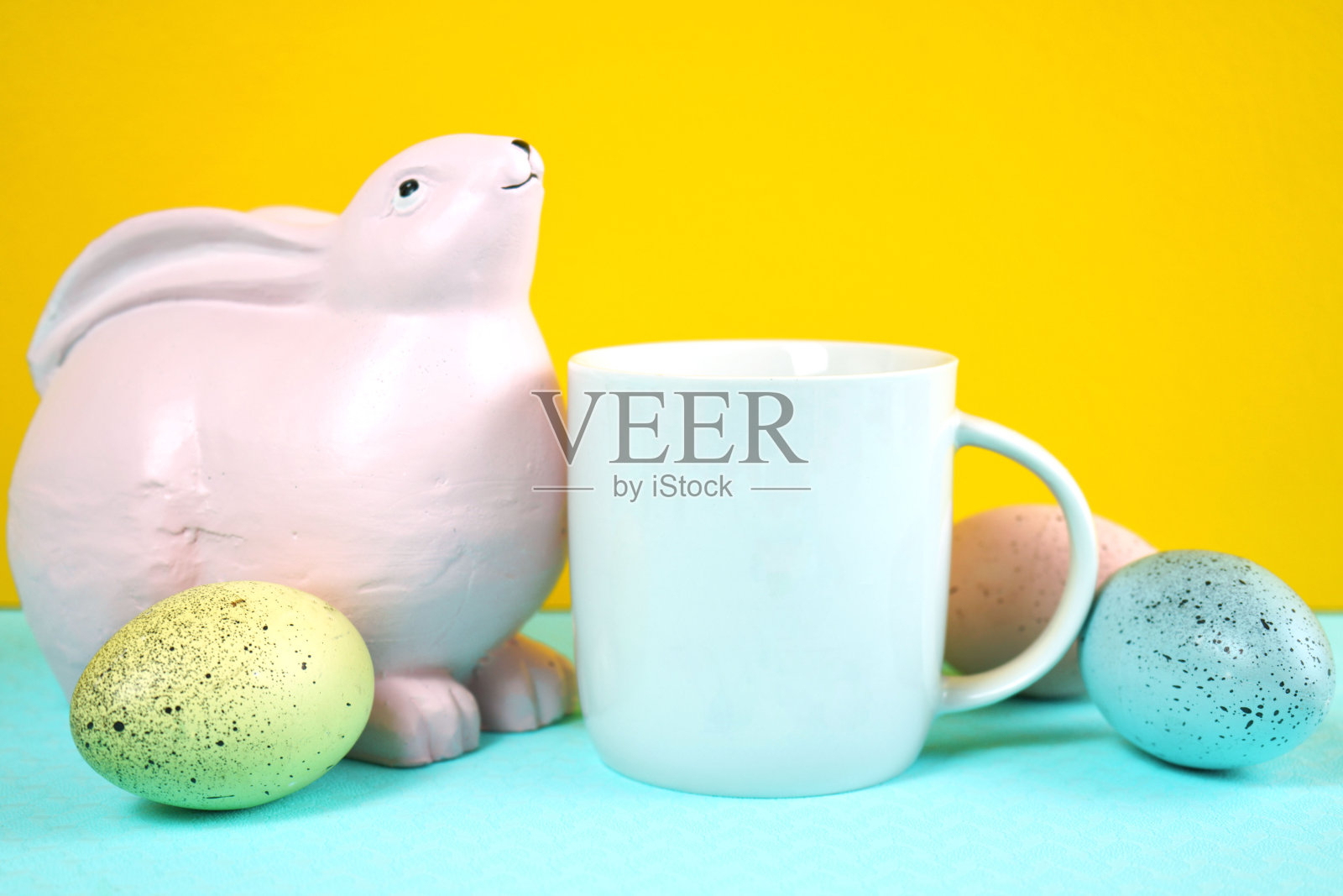 复活节产品模型与粉红色的兔子,复活节蛋在黄色的背景。照片摄影图片