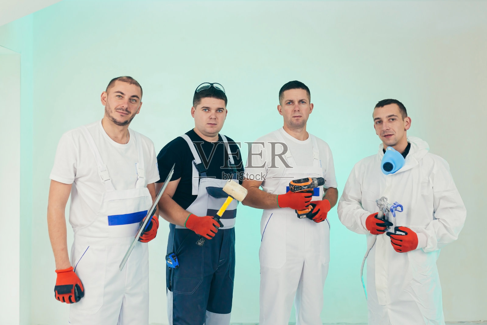 一组建筑工人,四个人,正在进行建筑和维修工作,他们看着镜头照片摄影图片