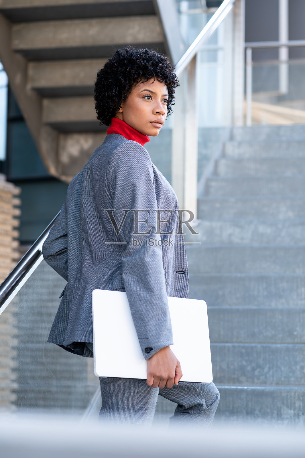 年轻的非裔美国女商人在公司办公大楼里使用她的手机和笔记本电脑照片摄影图片