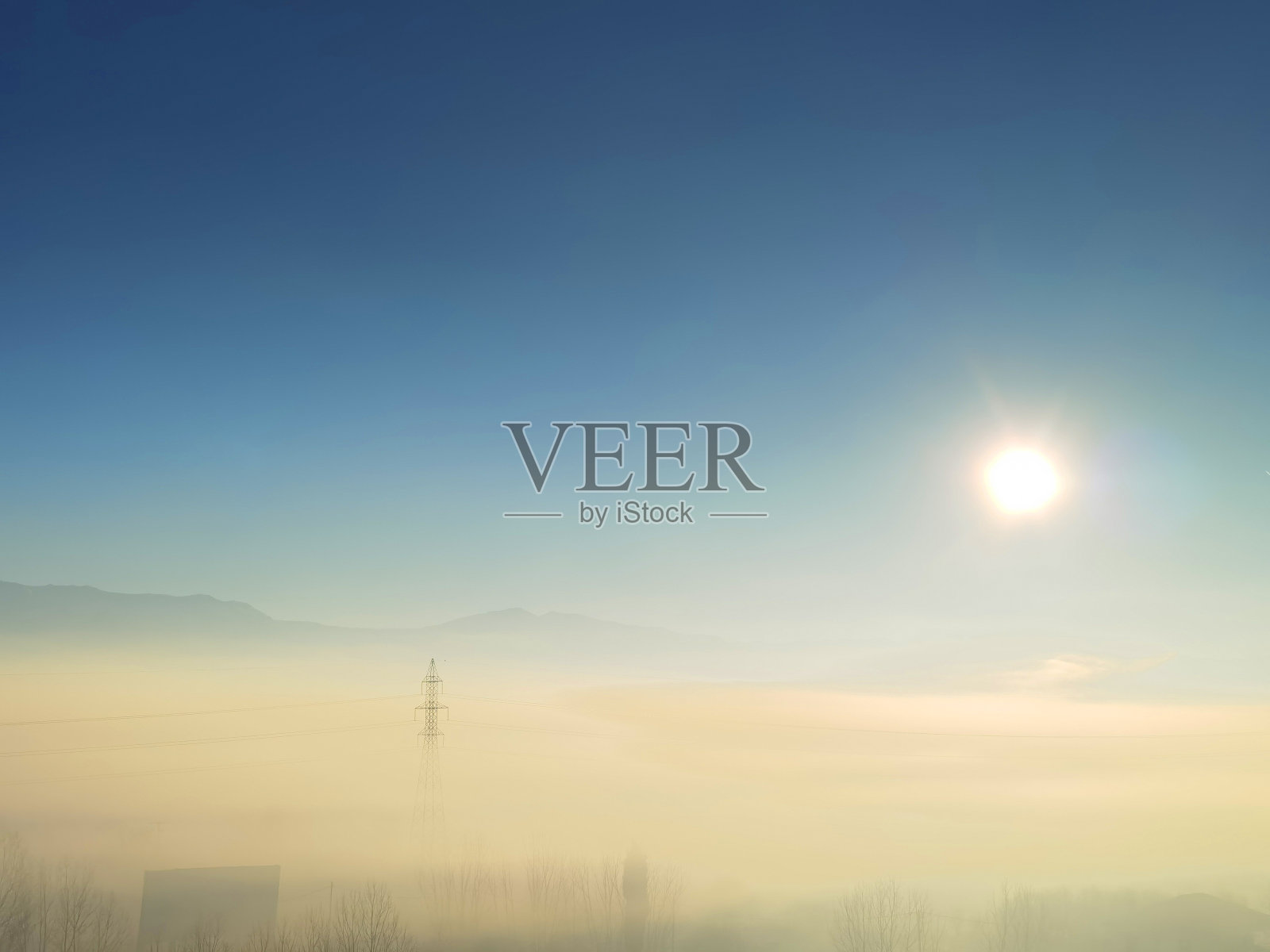 希腊约阿尼纳州斯塔夫拉基村的电塔晨雾中,太阳升起照片摄影图片