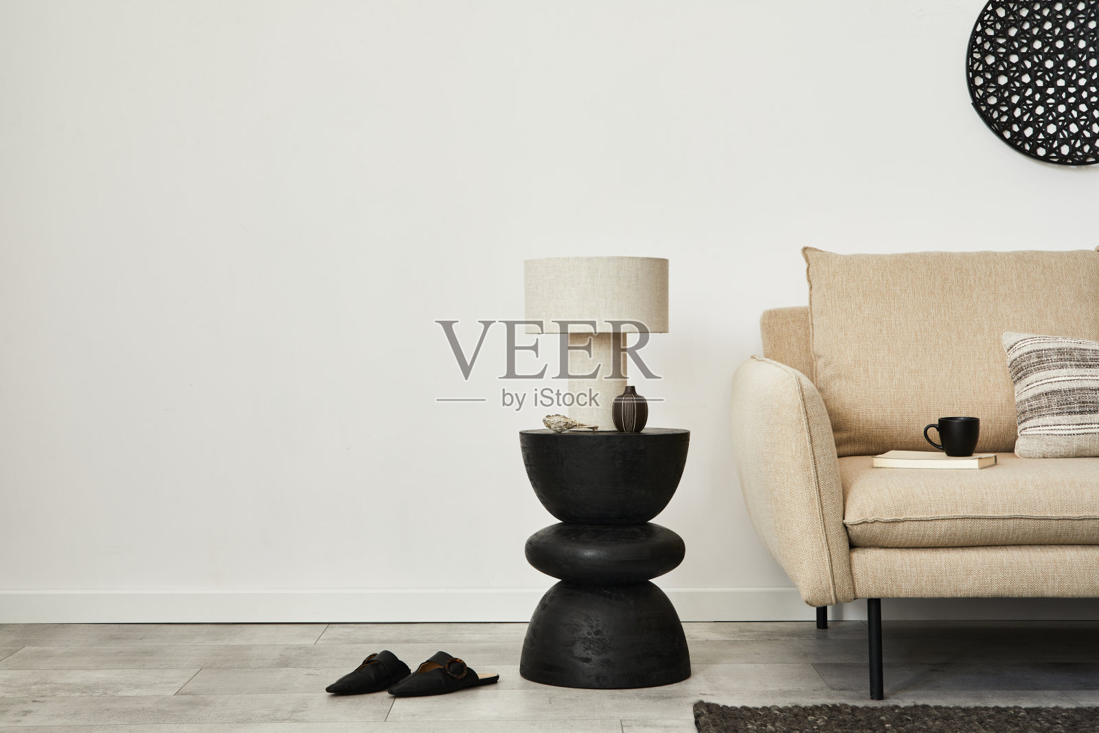 优雅简约的客厅内部的创意组成。米色现代沙发,边桌和时尚的个人配件。墙纸。副本的空间。模板。照片摄影图片