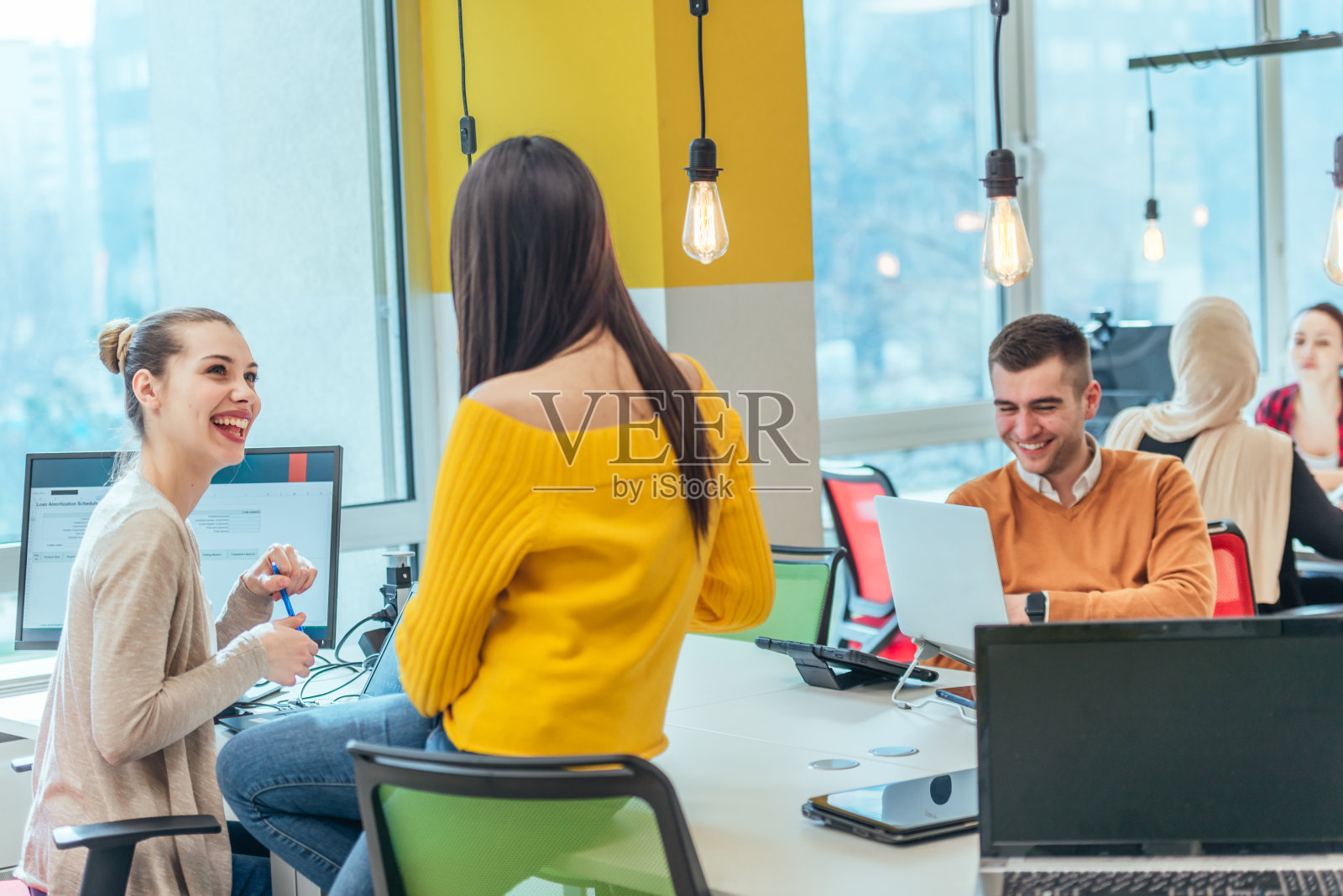 在一个数字项目中工作的团队。在创业环境中工作的一群同事。员工们在现代化的办公室里玩得很开心。照片摄影图片