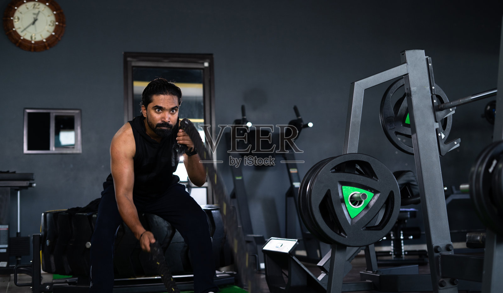 年轻的印度运动员在健身房训练中使用战斗或沉重的绳索锻炼-密集锻炼的概念,体操,决心和健美。照片摄影图片