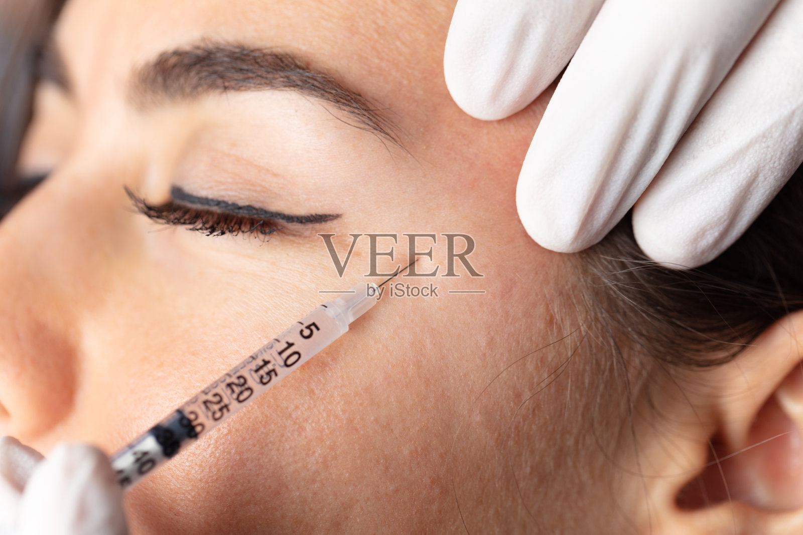 整形外科诊所。美容师手拿注射器进行注射。概念健康脸、护肤、中年护肤化妆品、美学。照片摄影图片