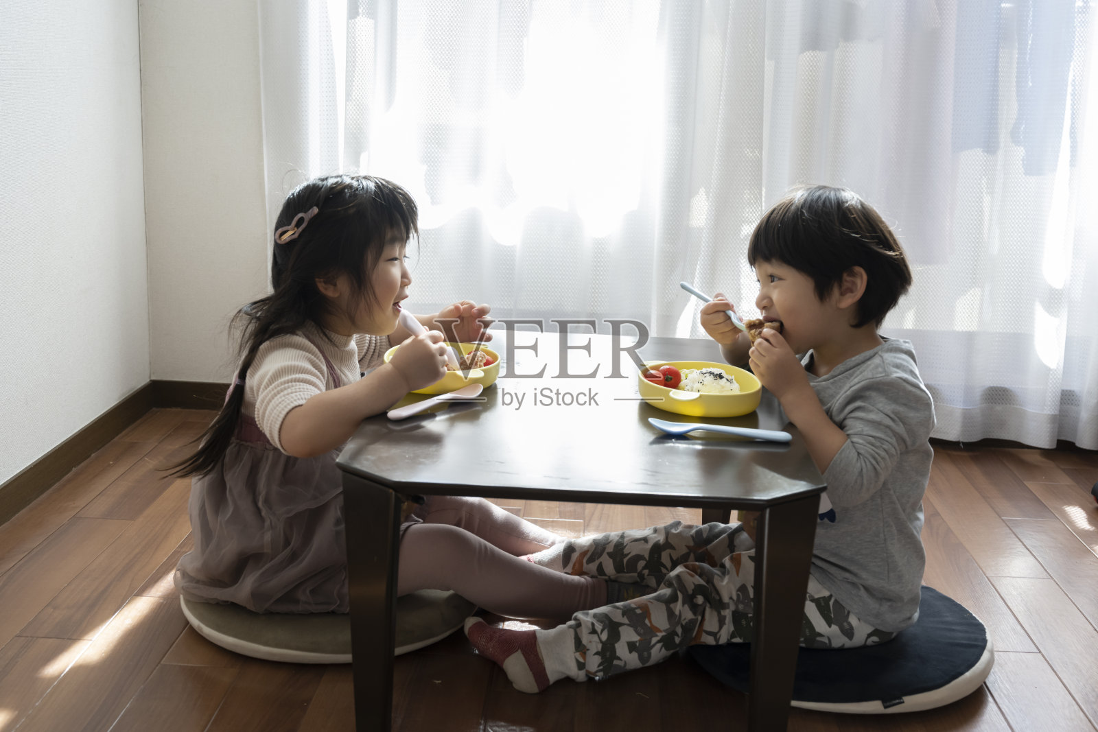 男孩和女孩吃糖果屋照片摄影图片