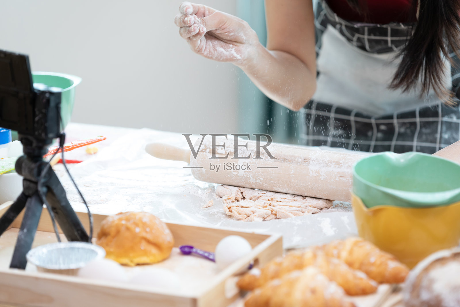 近距离的妇女与围裙擀面团在厨房的桌子上,并从摄像机在线记录流直播视频照片摄影图片