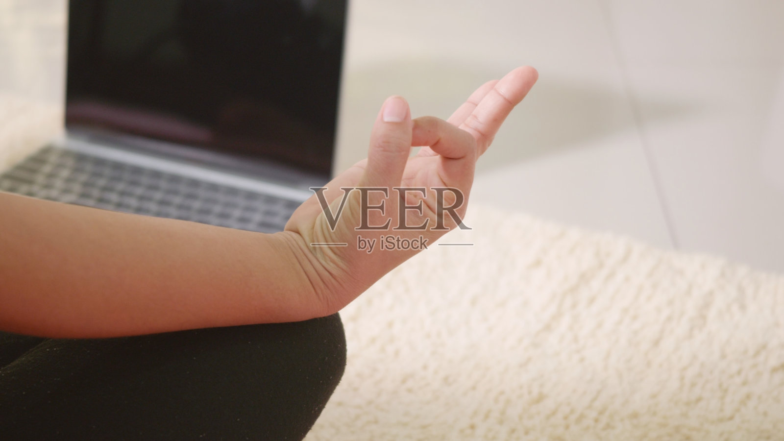 女人打底裤练习瑜伽在家里坐在瑜伽垫上的莲花姿势照片摄影图片