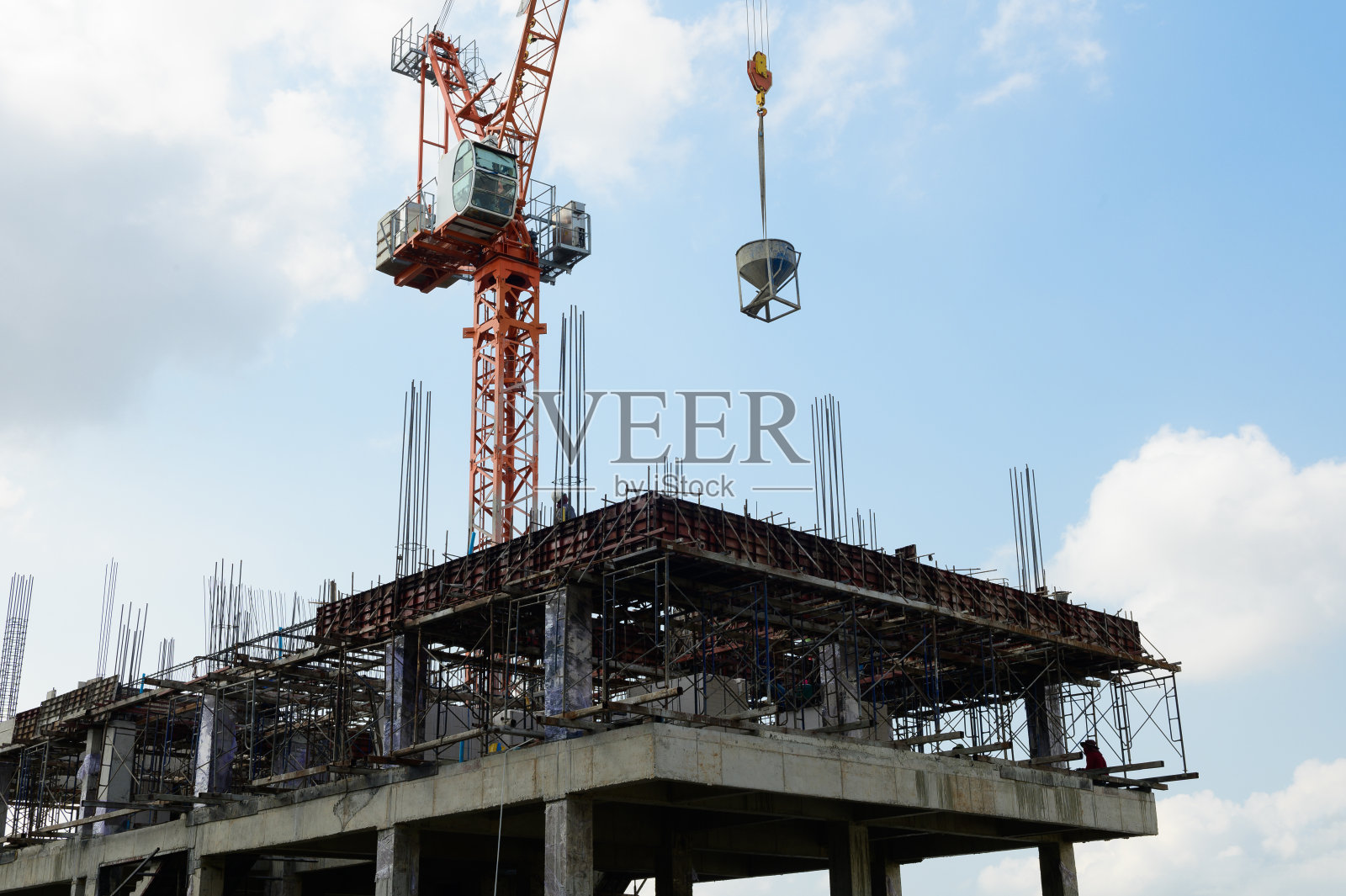 施工起重机将一罐混凝土带入施工结构中照片摄影图片