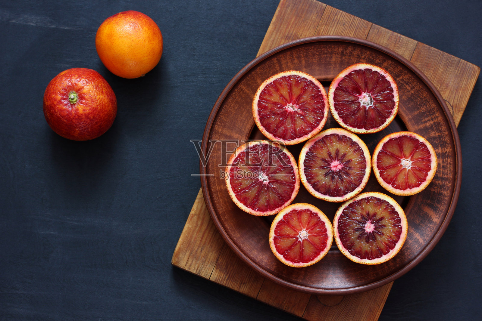 盘子上有血红色的橘子,俯视图。照片摄影图片