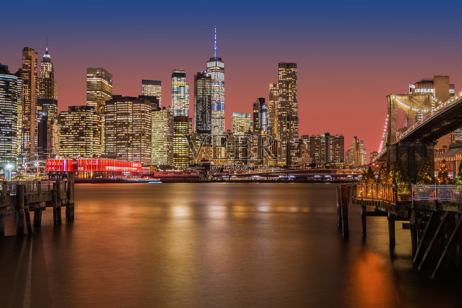 纽约的天际线,布鲁克林大桥,曼哈顿金融区和世界贸易中心与戏剧性的日落天空。照片摄影图片