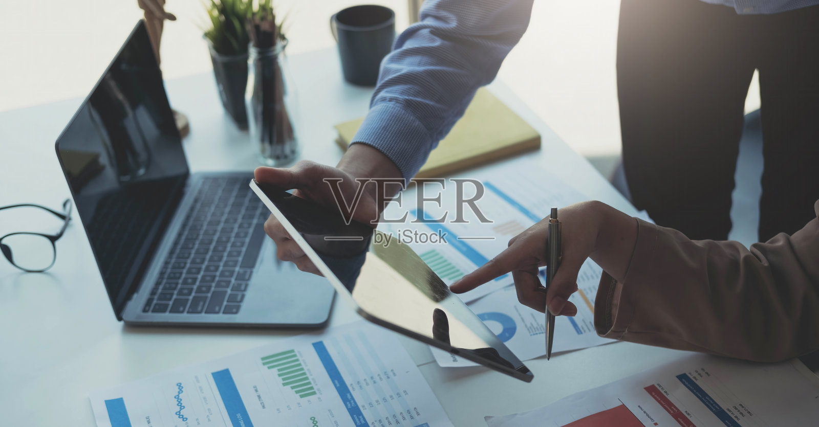 基金经理团队咨询和讨论分析投资股票市场数字平板电脑。照片摄影图片