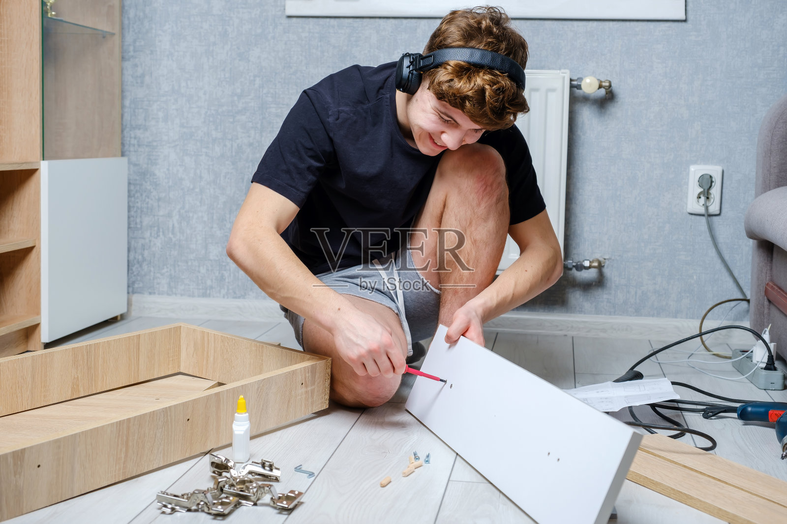 年轻人在地板上摆弄木制家具照片摄影图片