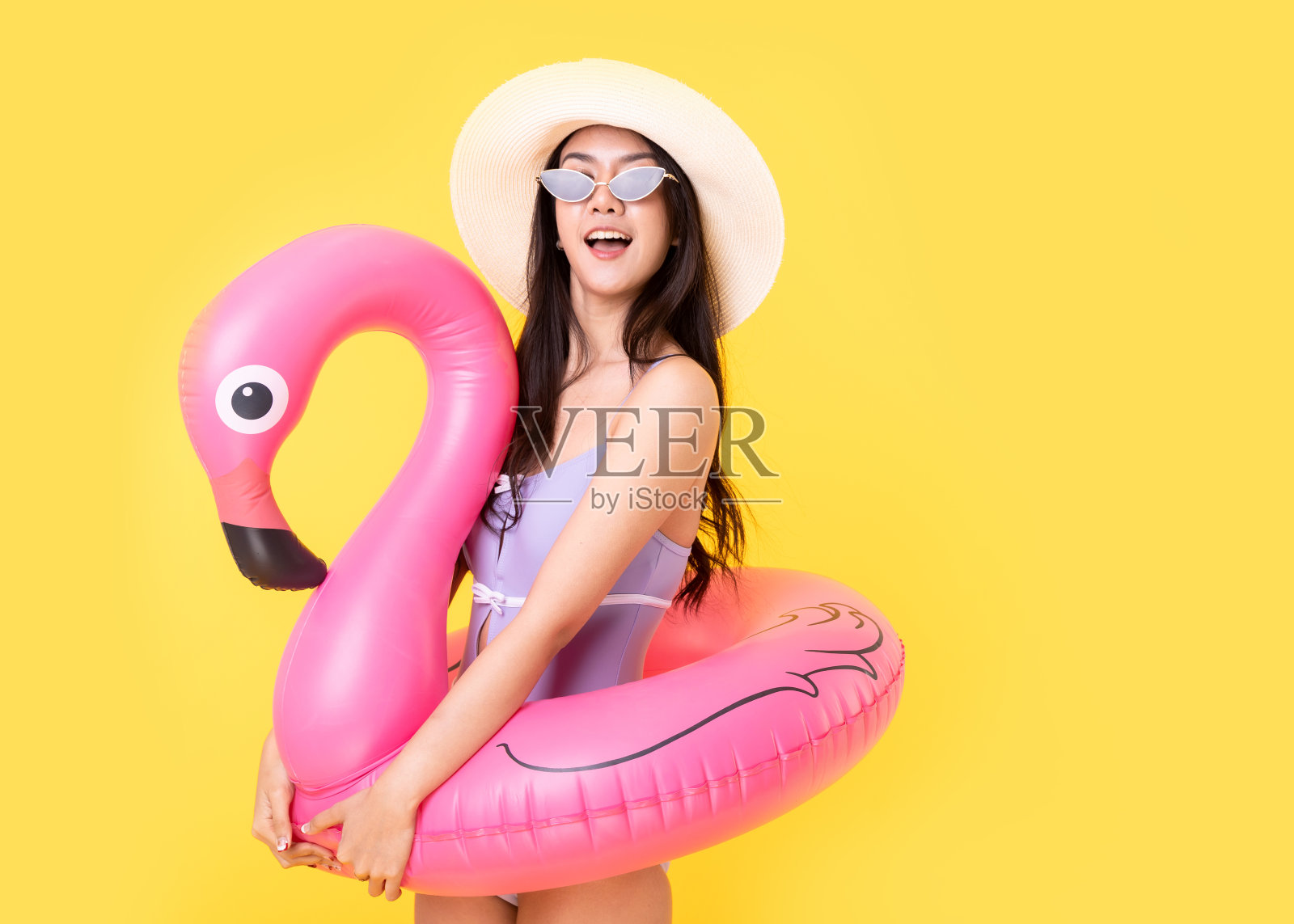 美丽性感的亚洲女人比基尼和微笑站在黄色背景孤立。暑假快乐旅行的概念。照片摄影图片