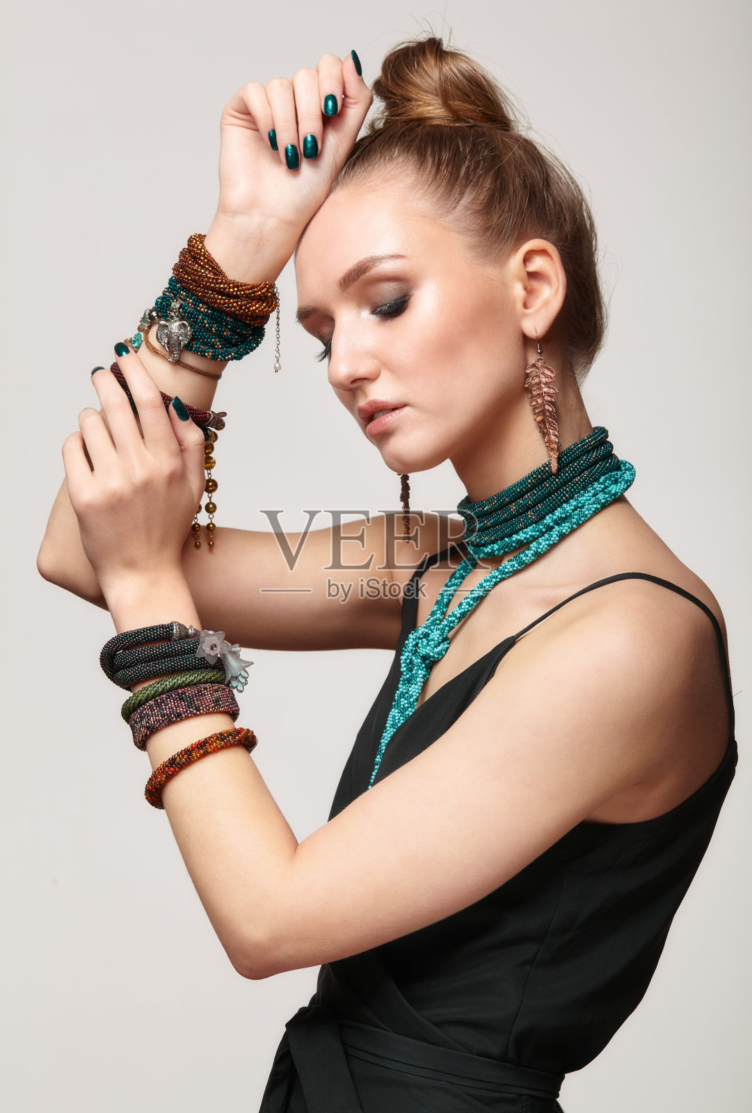 漂亮的女人在领项链和多个手镯。照片摄影图片