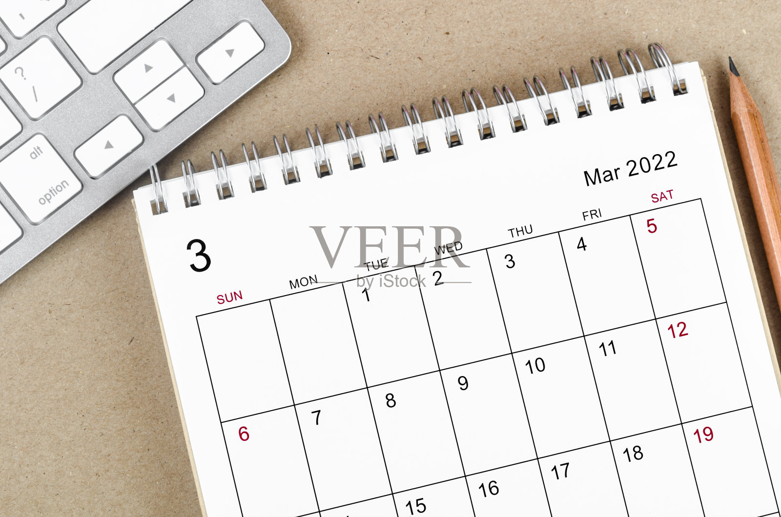 2022年3月木制背景铅笔台历。照片摄影图片