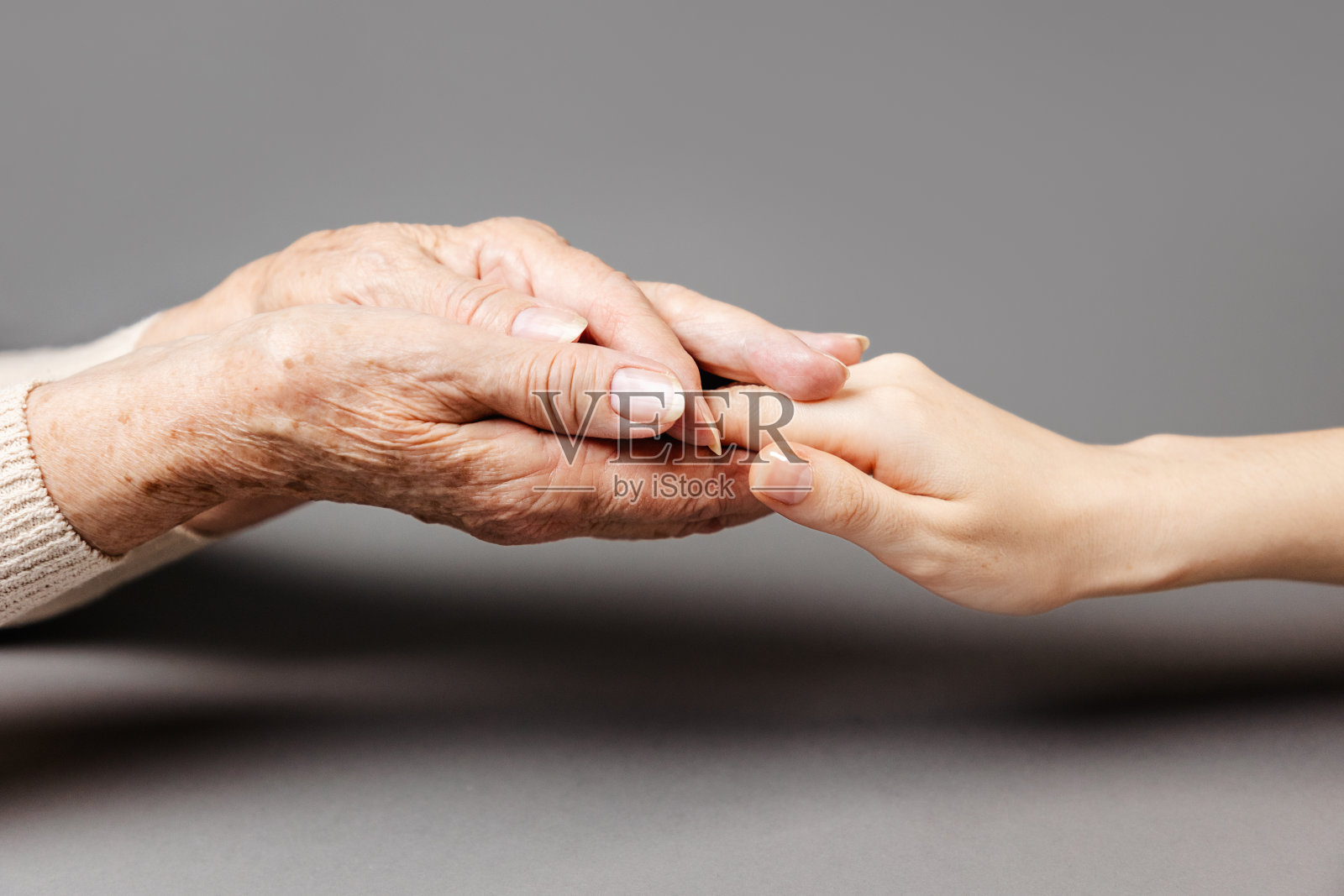 一位上了年纪的妇女把女儿的手握在手掌里。特写镜头。家庭观念,关心亲人照片摄影图片