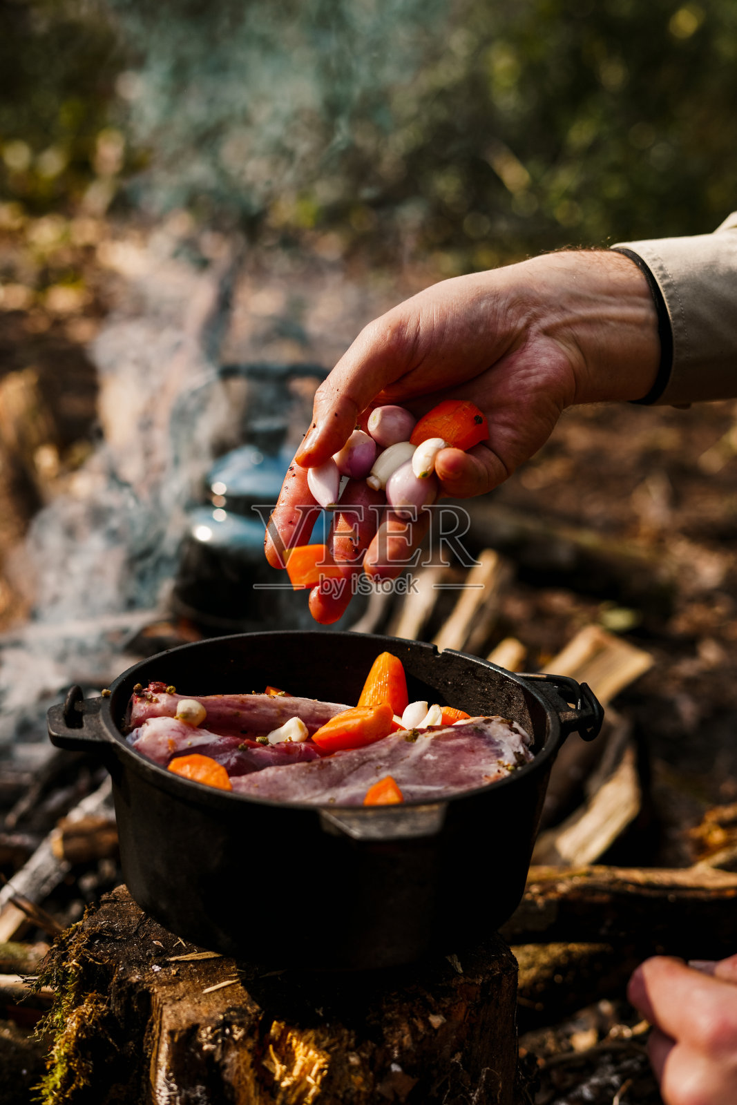 篝火煮肉。在野营烤箱里烤羊肩照片摄影图片