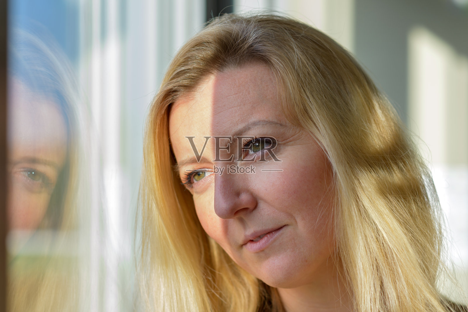 迷人的金发女人站在那里做白日梦照片摄影图片