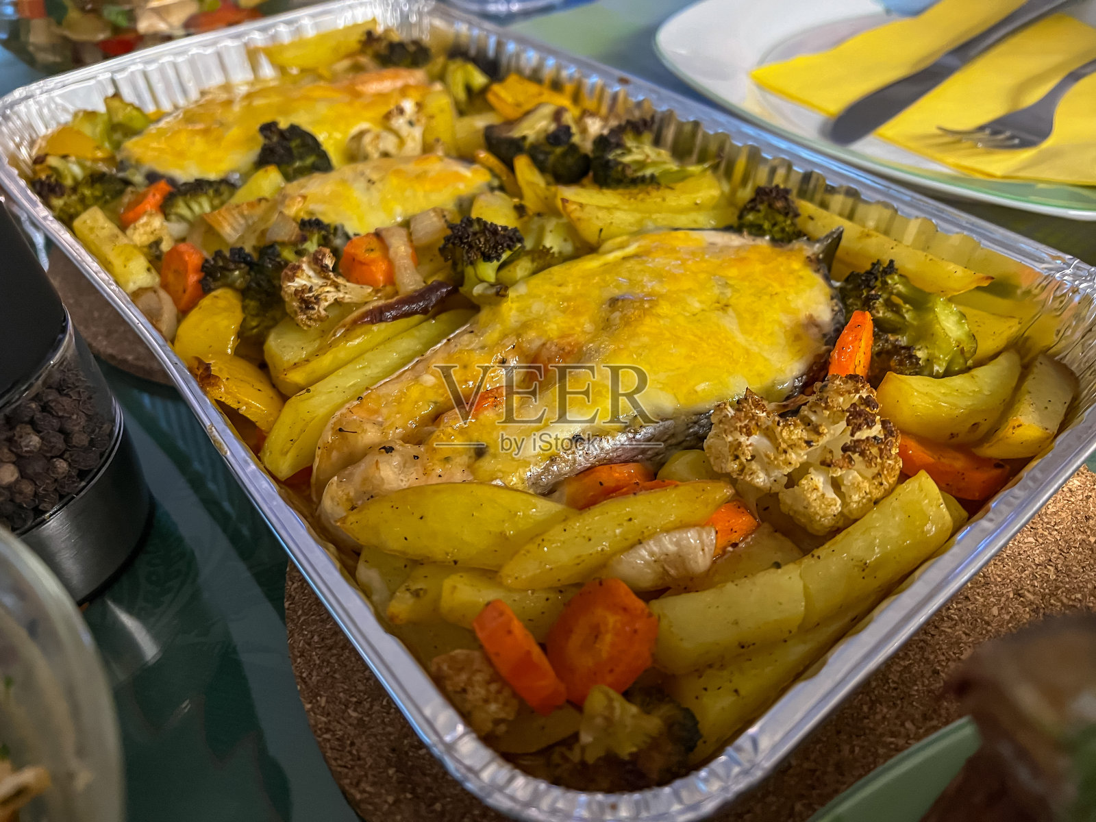 烤箱里的三文鱼配奶酪,土豆,胡萝卜和花椰菜。照片摄影图片