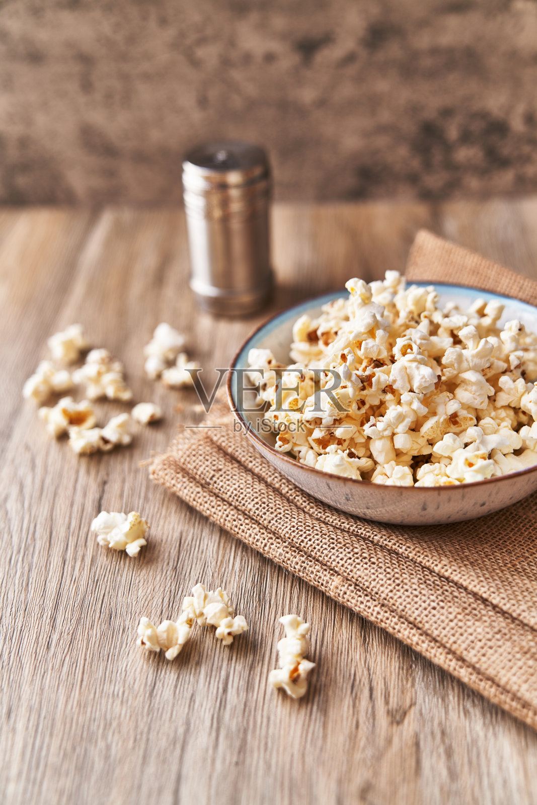 一碗咸爆米花放在木头表面照片摄影图片