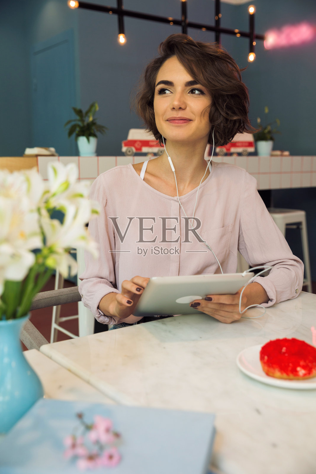 微笑的小女孩听着音乐,戴着耳机照片摄影图片