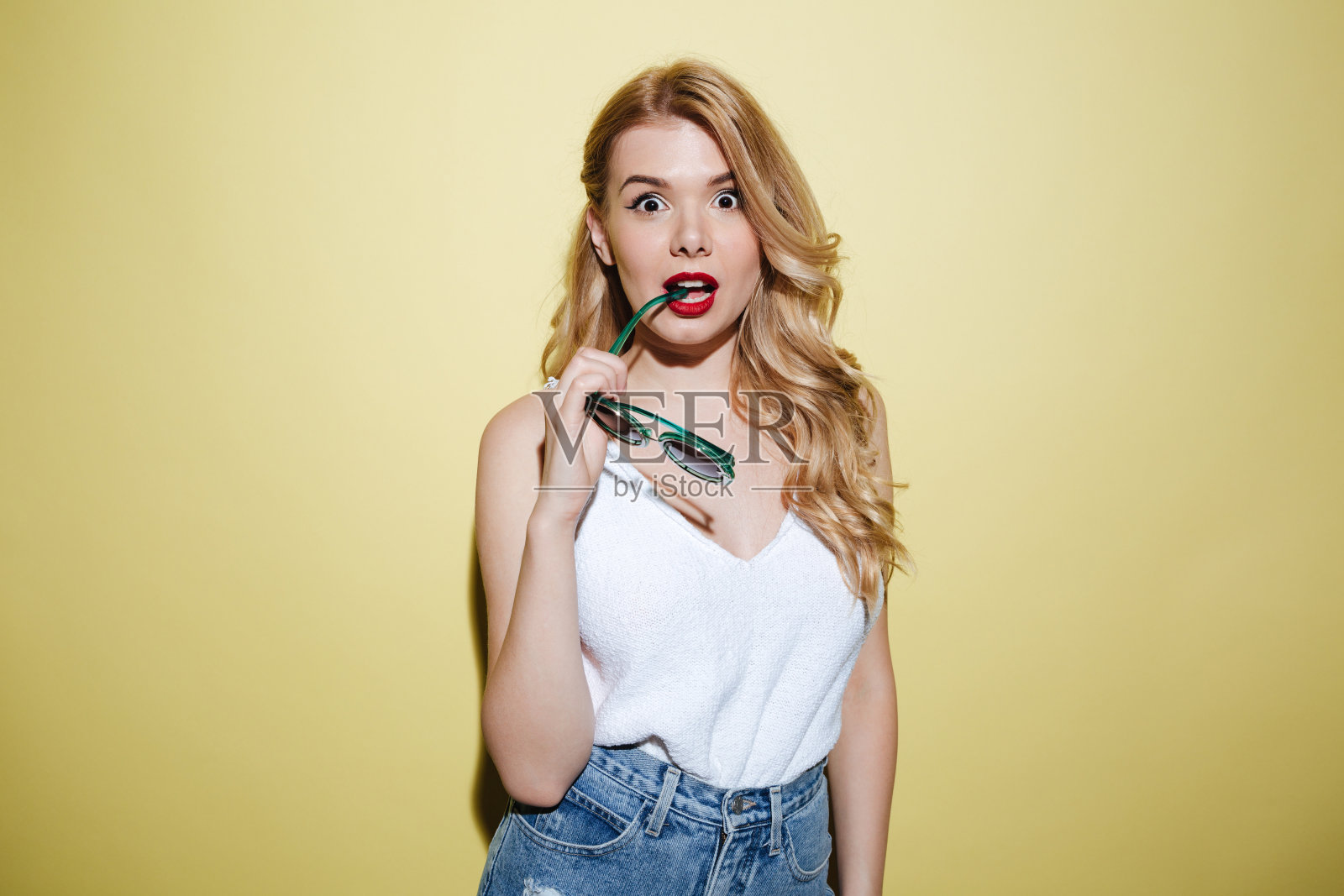 年轻迷茫的女人拿着墨镜看着相机照片摄影图片