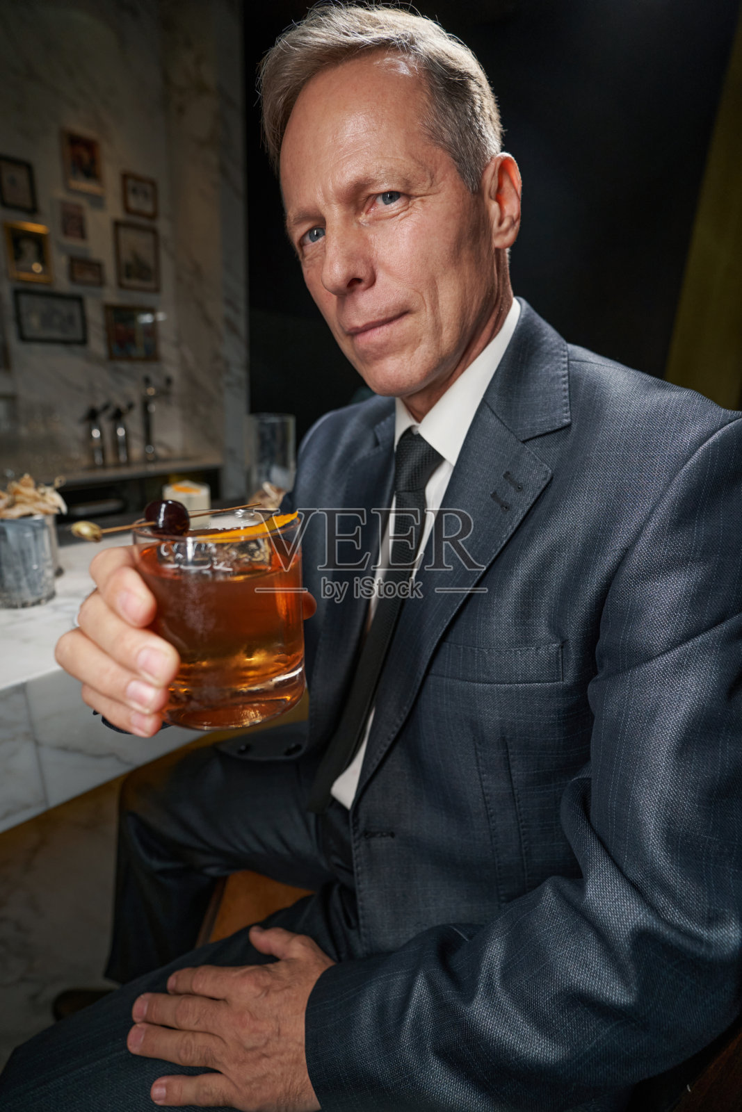 优雅的绅士在酒吧喝着饮料照片摄影图片
