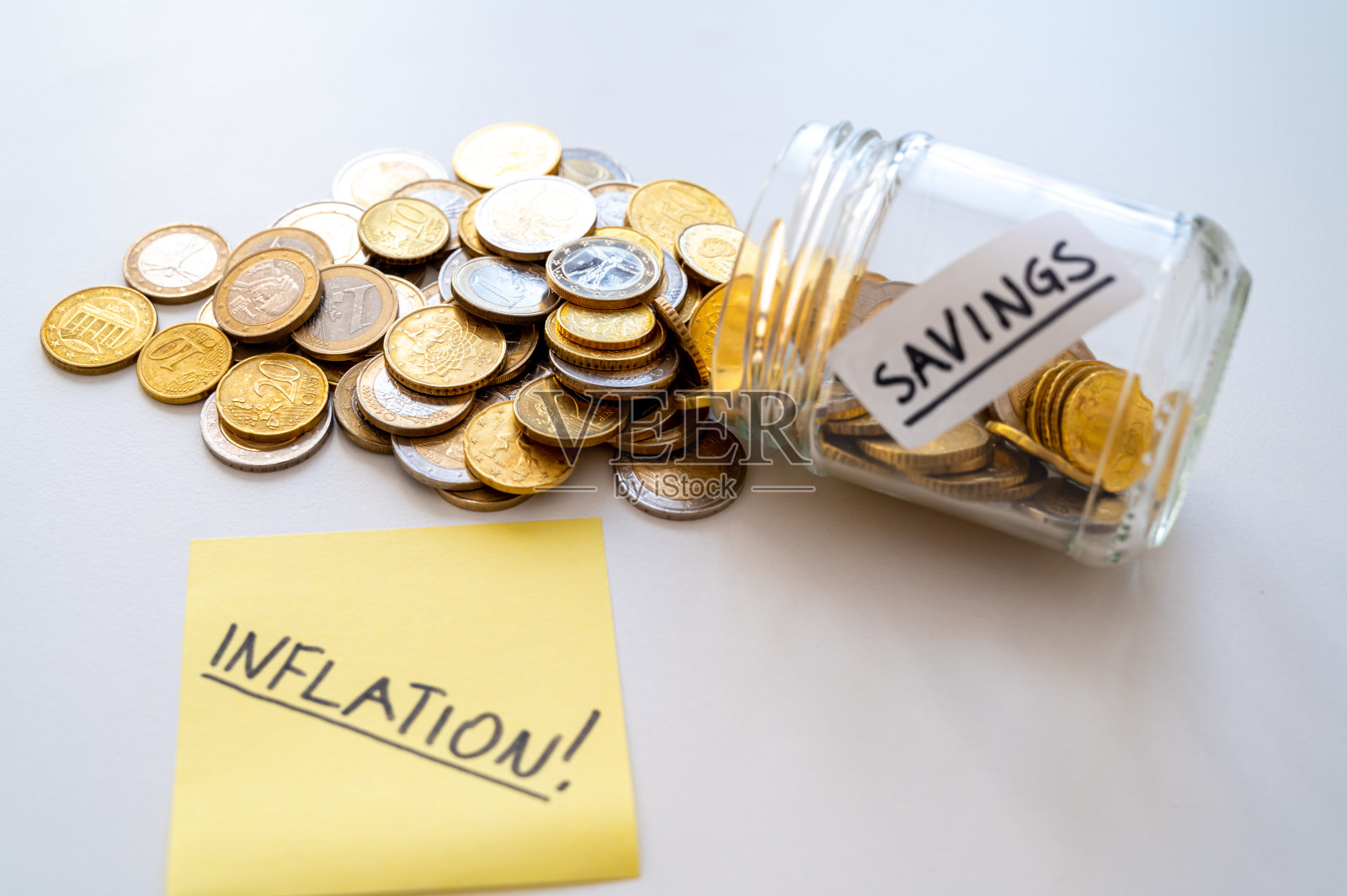 存钱罐,里面有硬币和印有“通货膨胀”字样的卡片。通货膨胀和物价上涨照片摄影图片