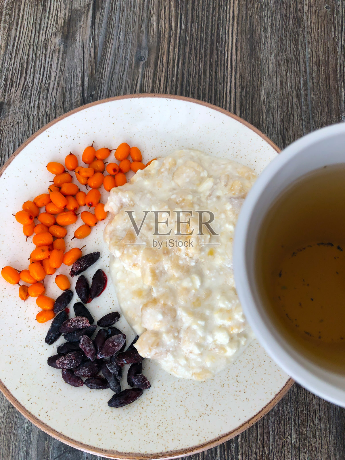 白干酪配香蕉金银花和沙棘和茶。健康早餐。照片摄影图片