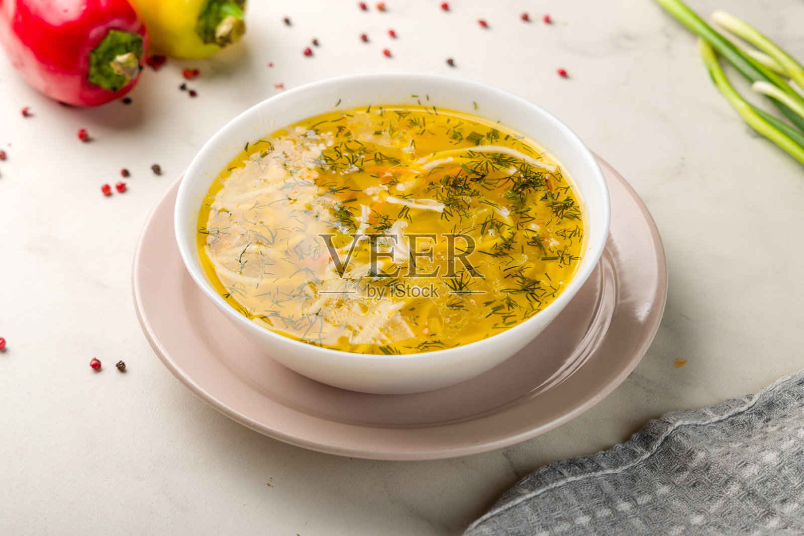 白色大理石桌子上的盘子里盛着鸡汤照片摄影图片