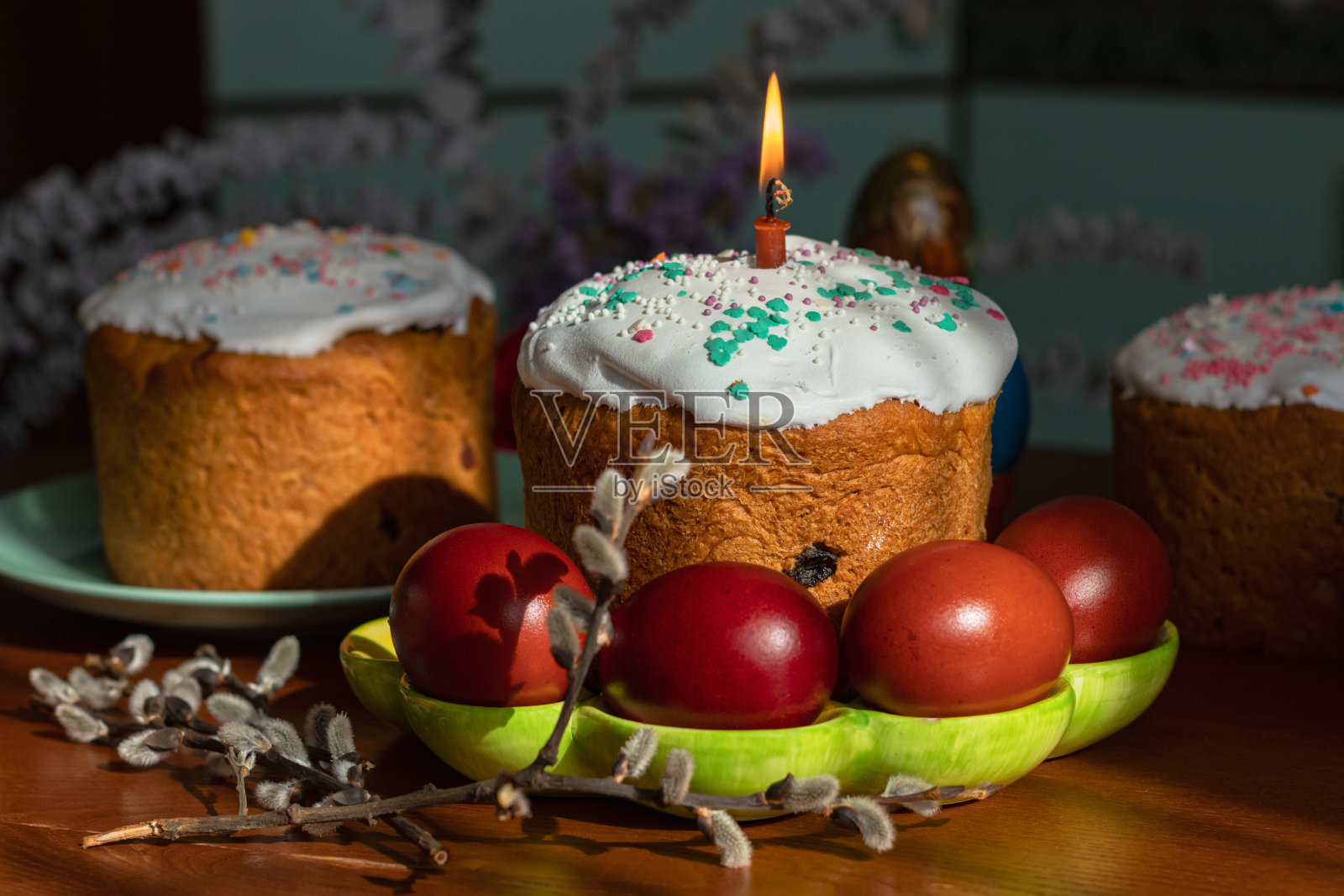 优雅的复活节蛋糕和燃烧的蜡烛放在餐桌上照片摄影图片