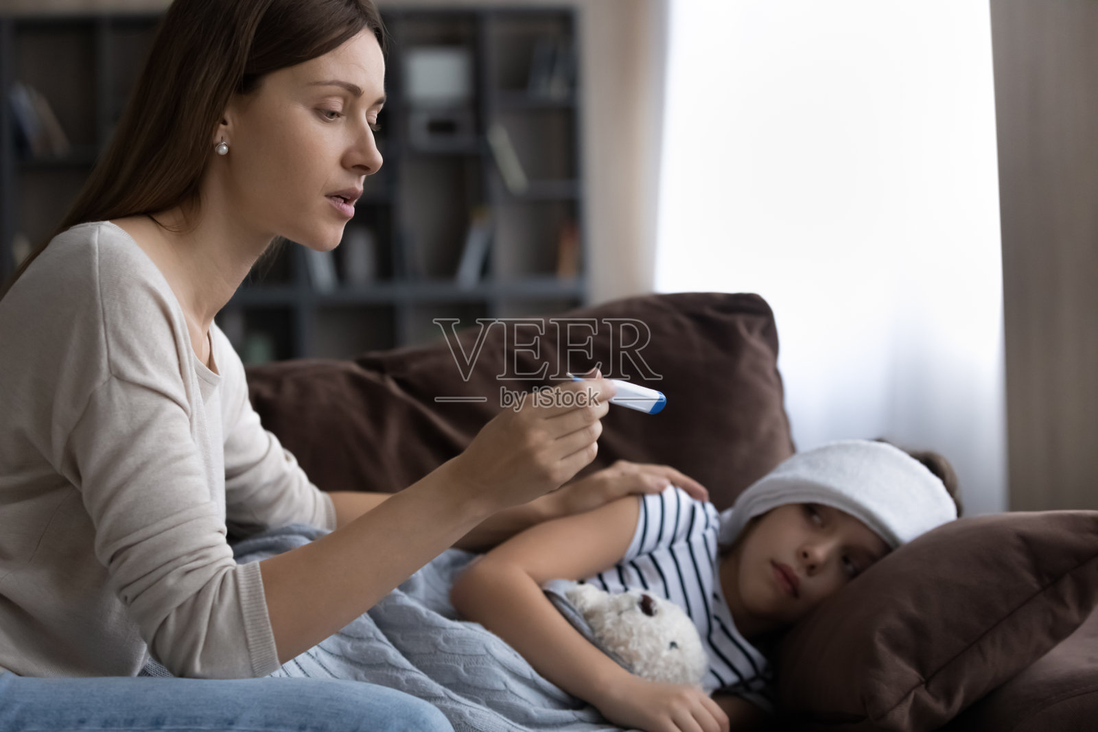 慈母拿着体温计,检查生病的小女儿的体温照片摄影图片