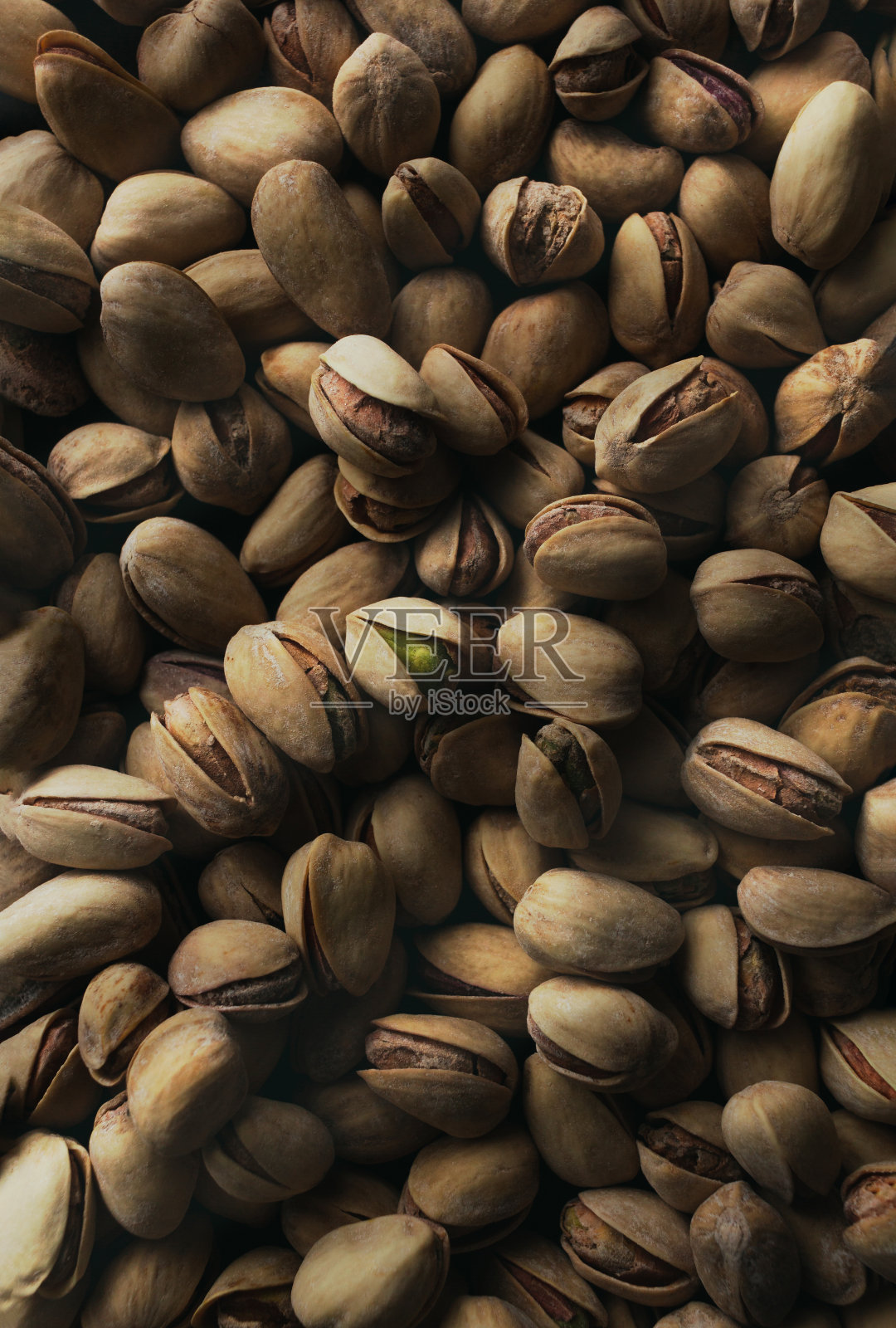 在黑暗的背景上烤开心果的俯视图。照片摄影图片