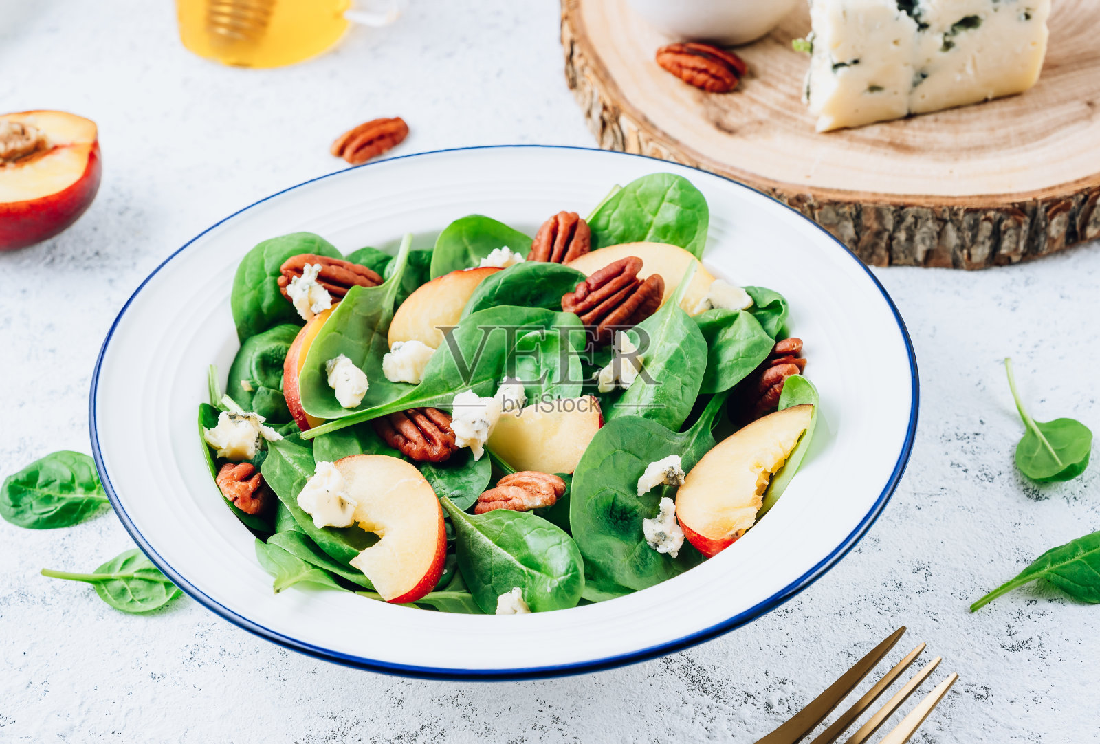 健康的夏季沙拉,菠菜,桃子,核桃,蓝奶酪白色背景照片摄影图片