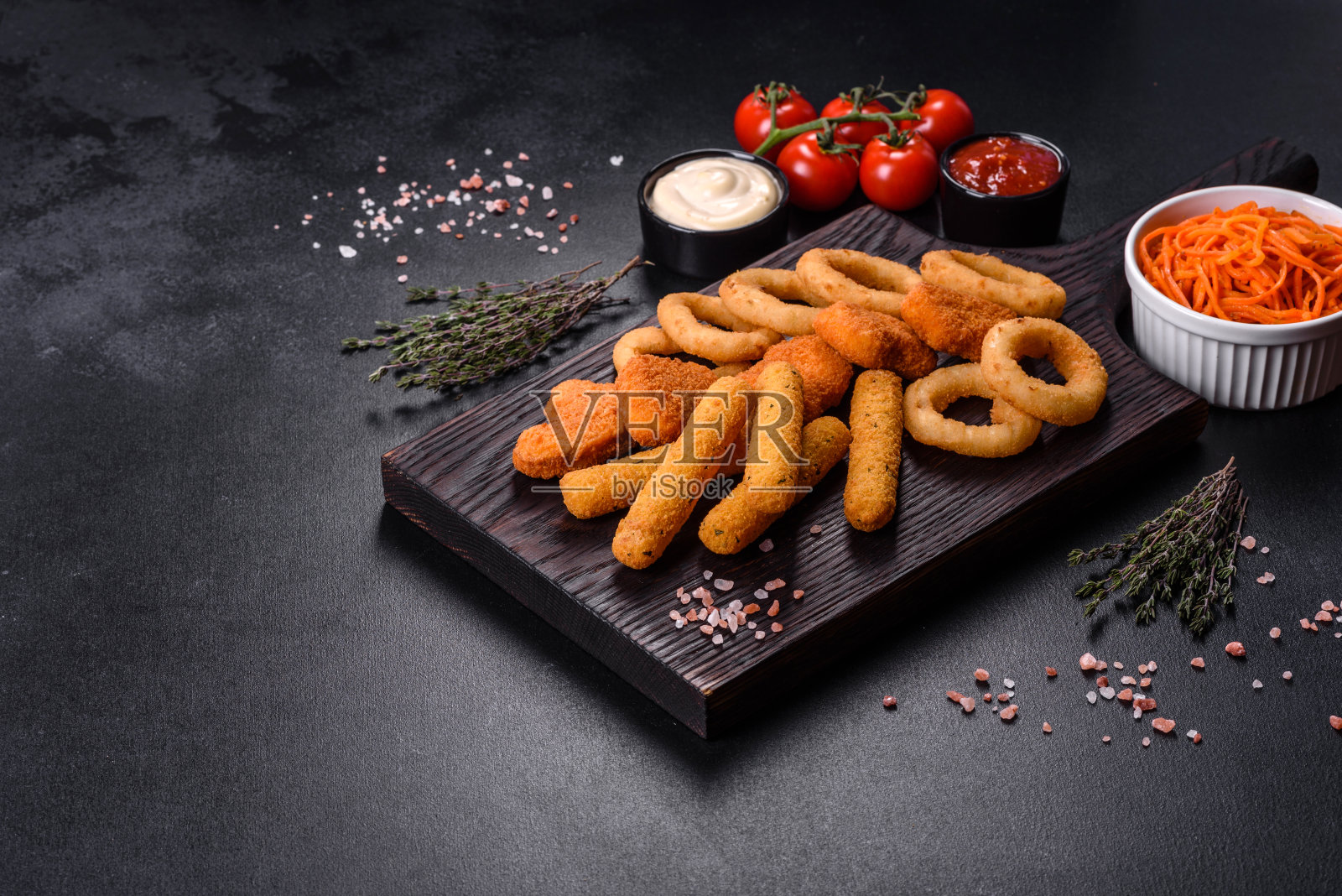 小吃拼盘-芝士条,鸡块,洋葱圈混合小吃和酱料照片摄影图片