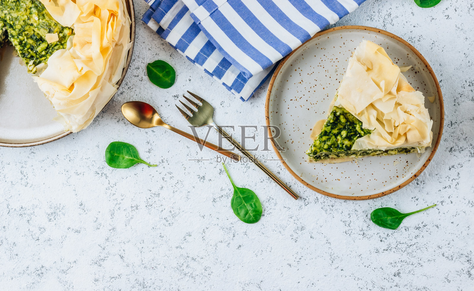 白底羊乳酪素食菠菜派。传统的希腊菠菜派照片摄影图片