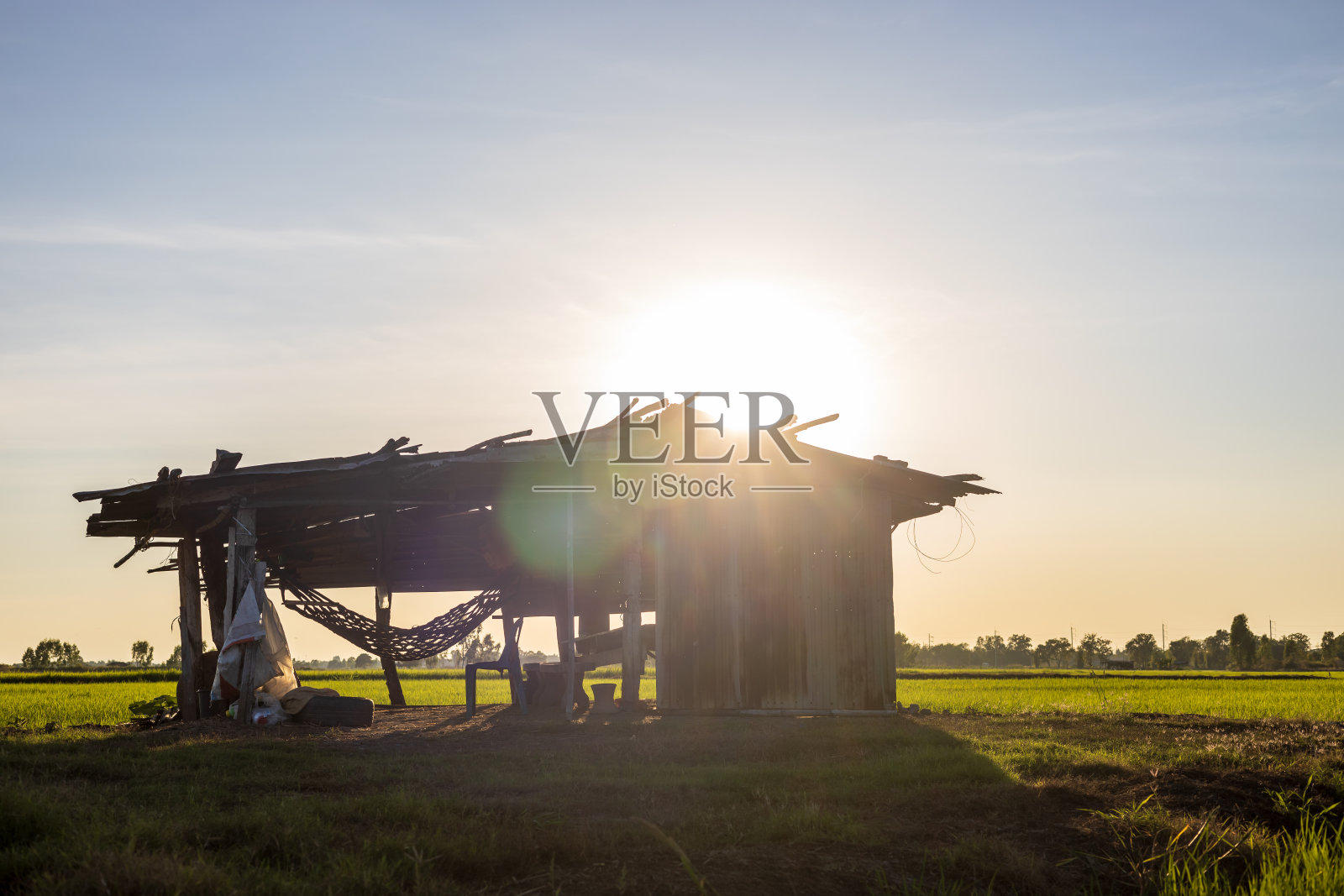 这是一间旧小屋的低角特写,在午后的阳光下拍摄,阳光投射出耀斑。照片摄影图片