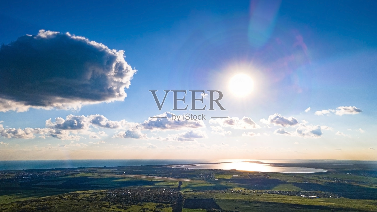 明亮的太阳在蓝色的天空和一大团积云照片摄影图片