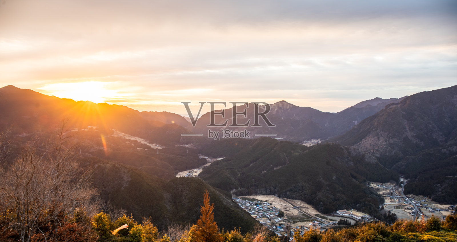 从乡村小镇的高处俯瞰山脉上的日出照片摄影图片