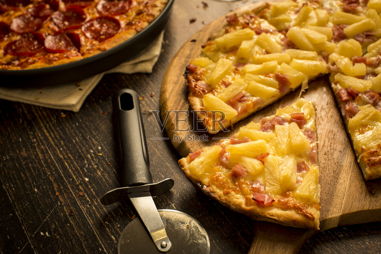 木桌上放着夏威夷披萨和意大利辣香肠披萨照片摄影图片