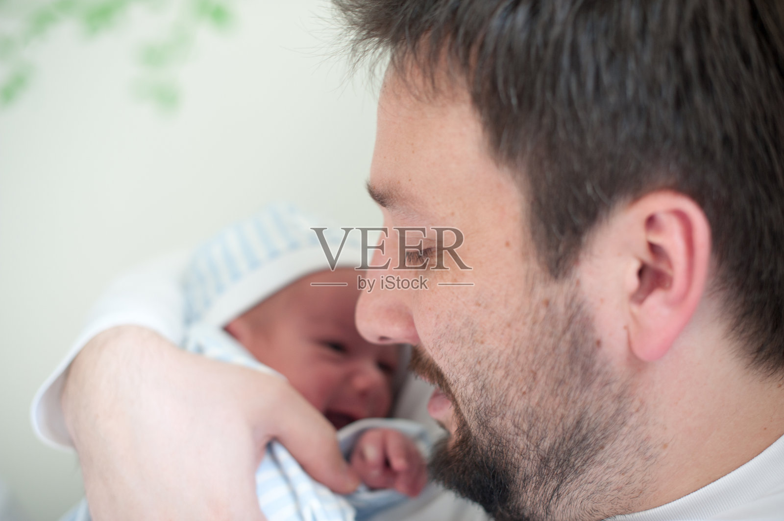 一个怀抱着新生婴儿的快乐慈爱的父亲照片摄影图片