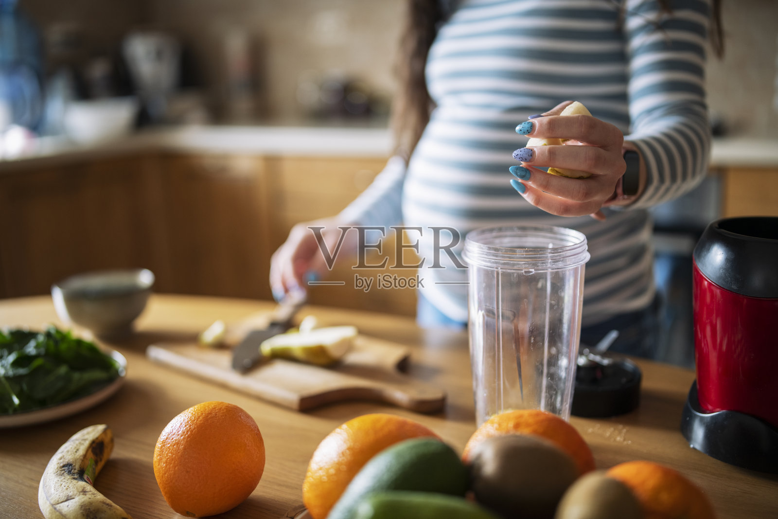 年轻孕妇正在做健康早餐。照片摄影图片