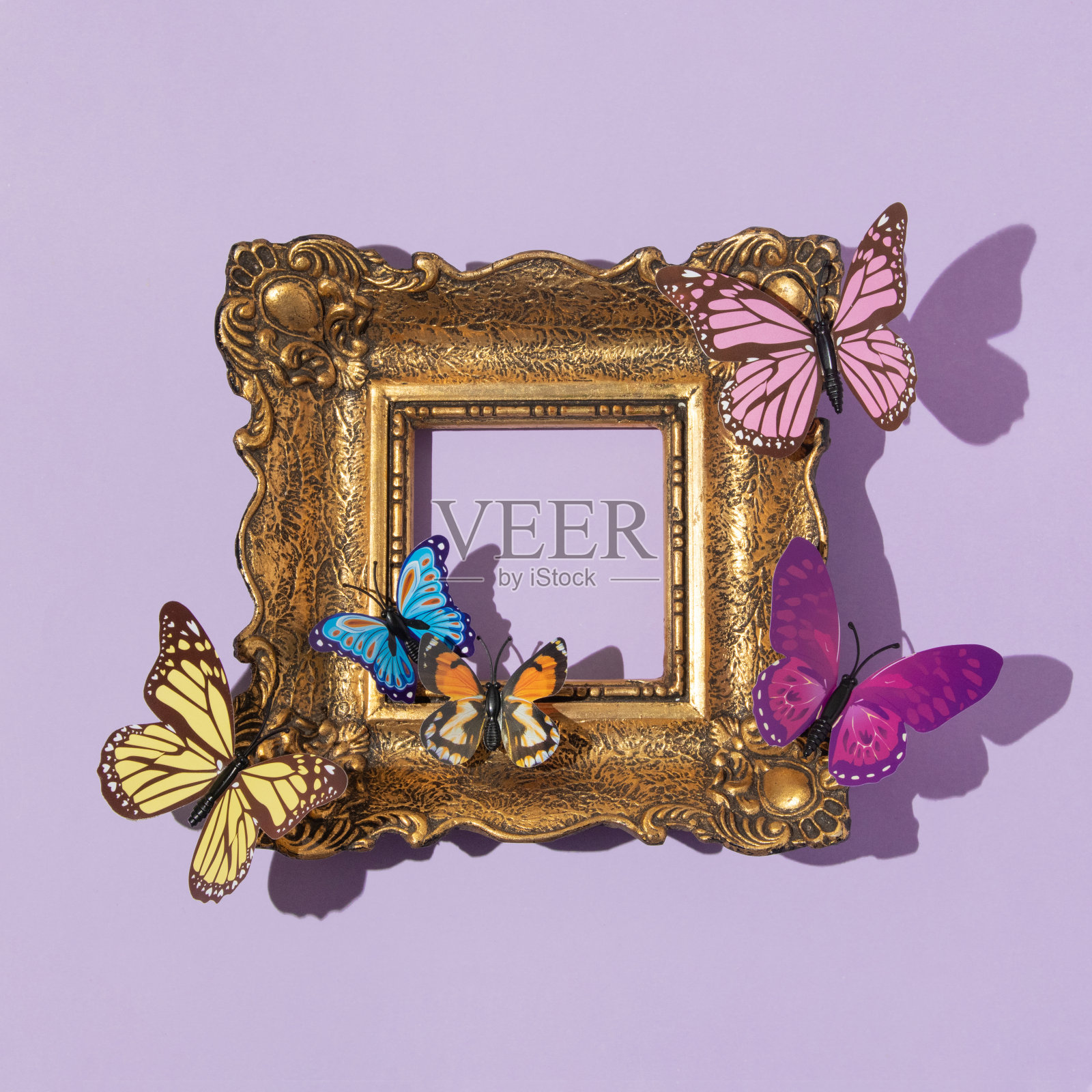 春天的创意布局与彩色蝴蝶和复古绘画框架上柔和的紫色背景。80年代、90年代复古浪漫唯美的夏日概念。简约超现实的时尚理念。照片摄影图片