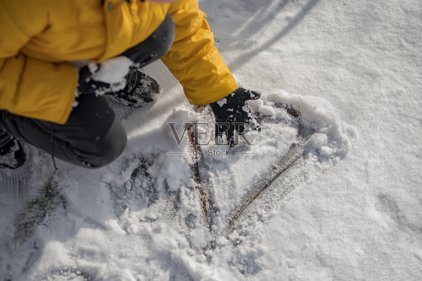 俯视图,在寒冷的天气里,在自然纯白的软雪表面手绘心形照片摄影图片