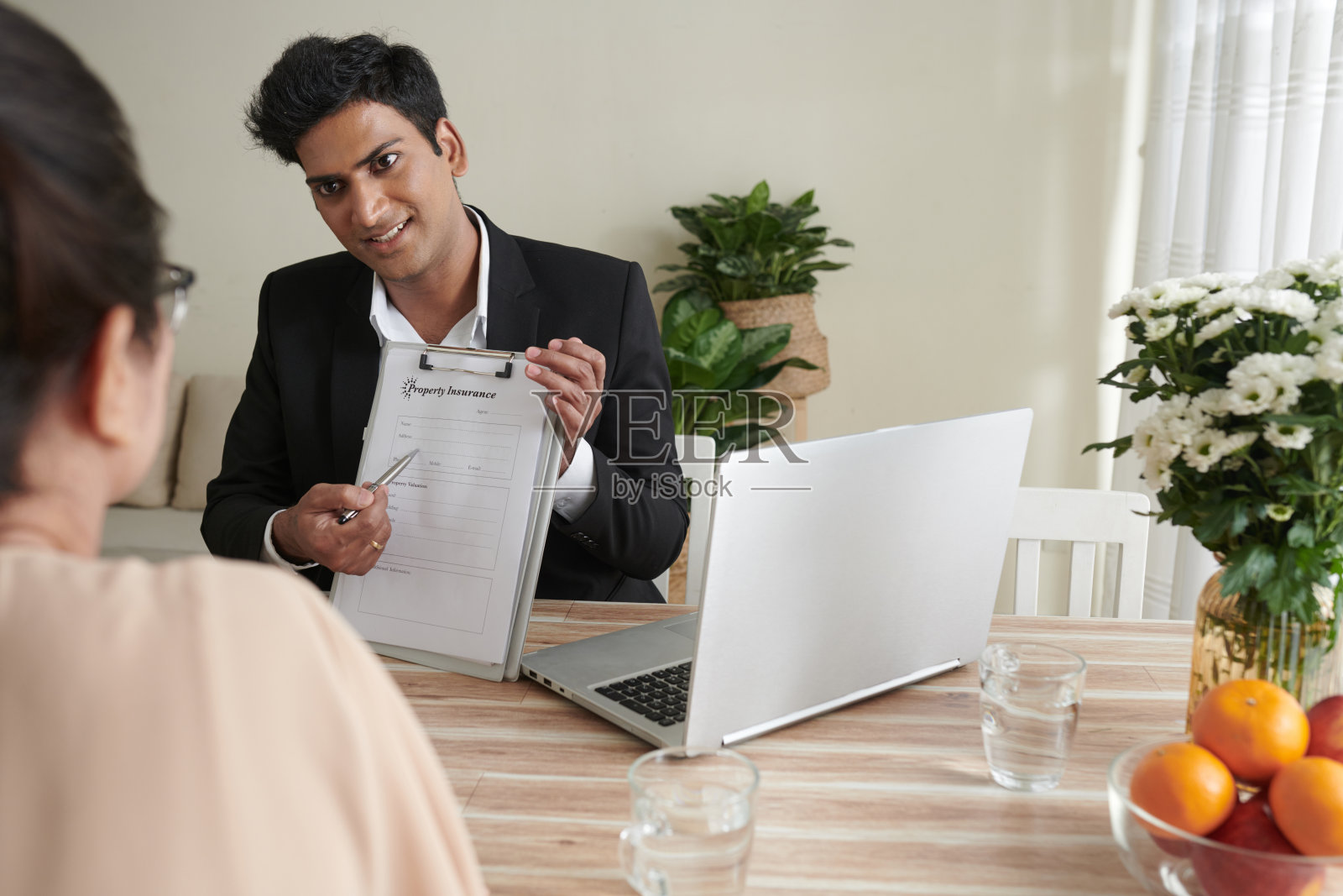 保险代理人向客户出示表格照片摄影图片
