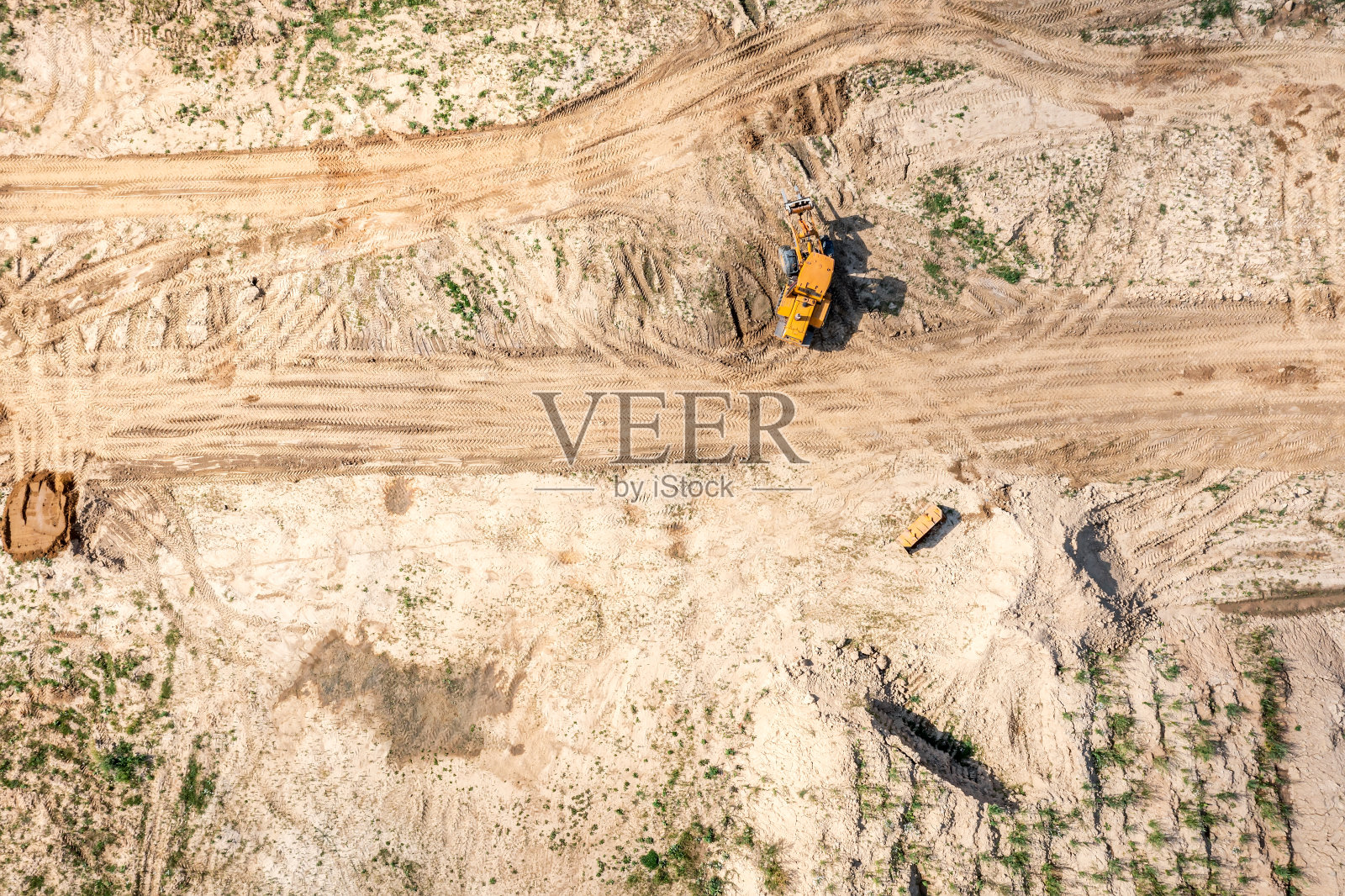 重型黄色平地机在建筑工地平整地面。无人机俯视图。照片摄影图片
