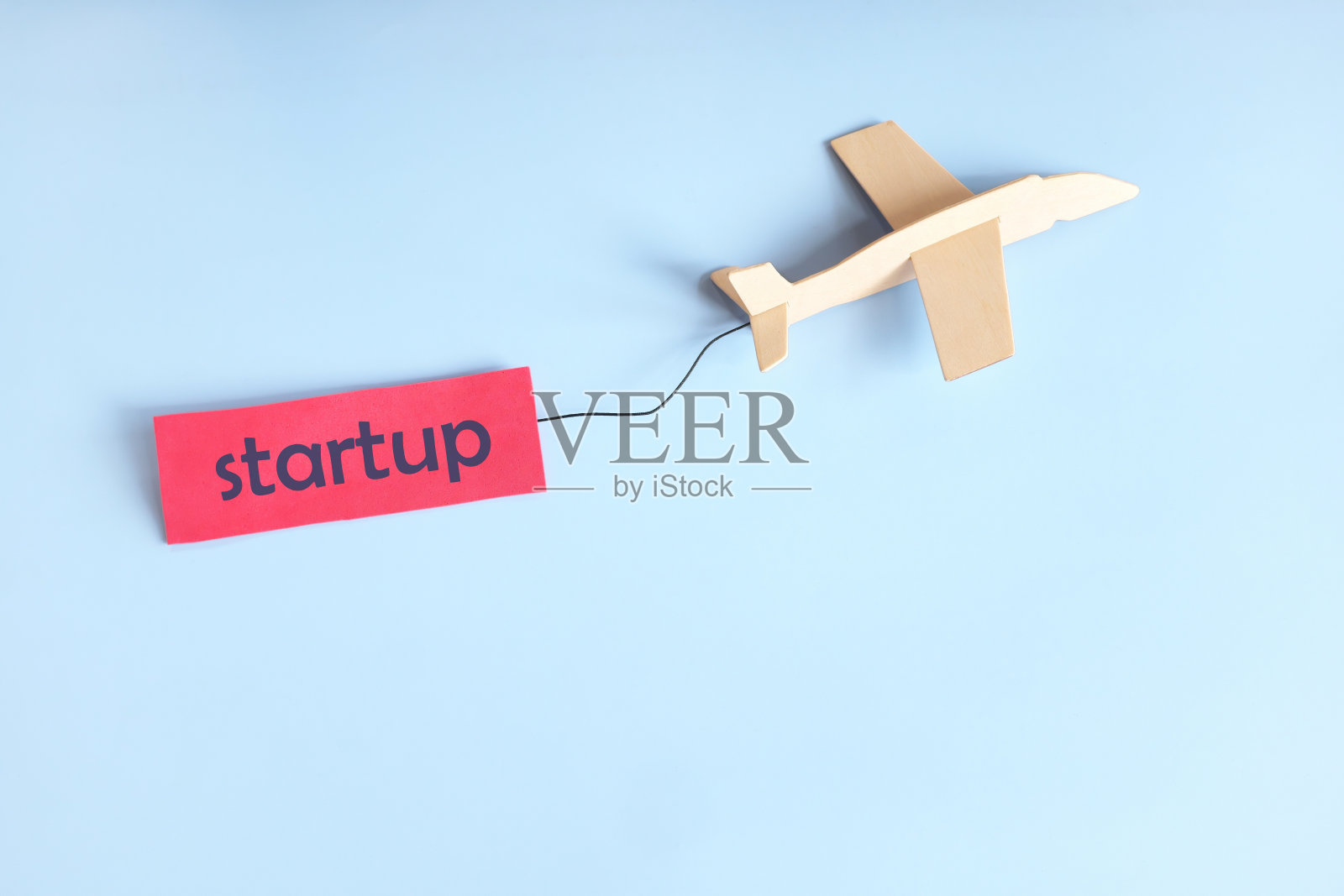 创业启动理念。木制飞机挂着。照片摄影图片